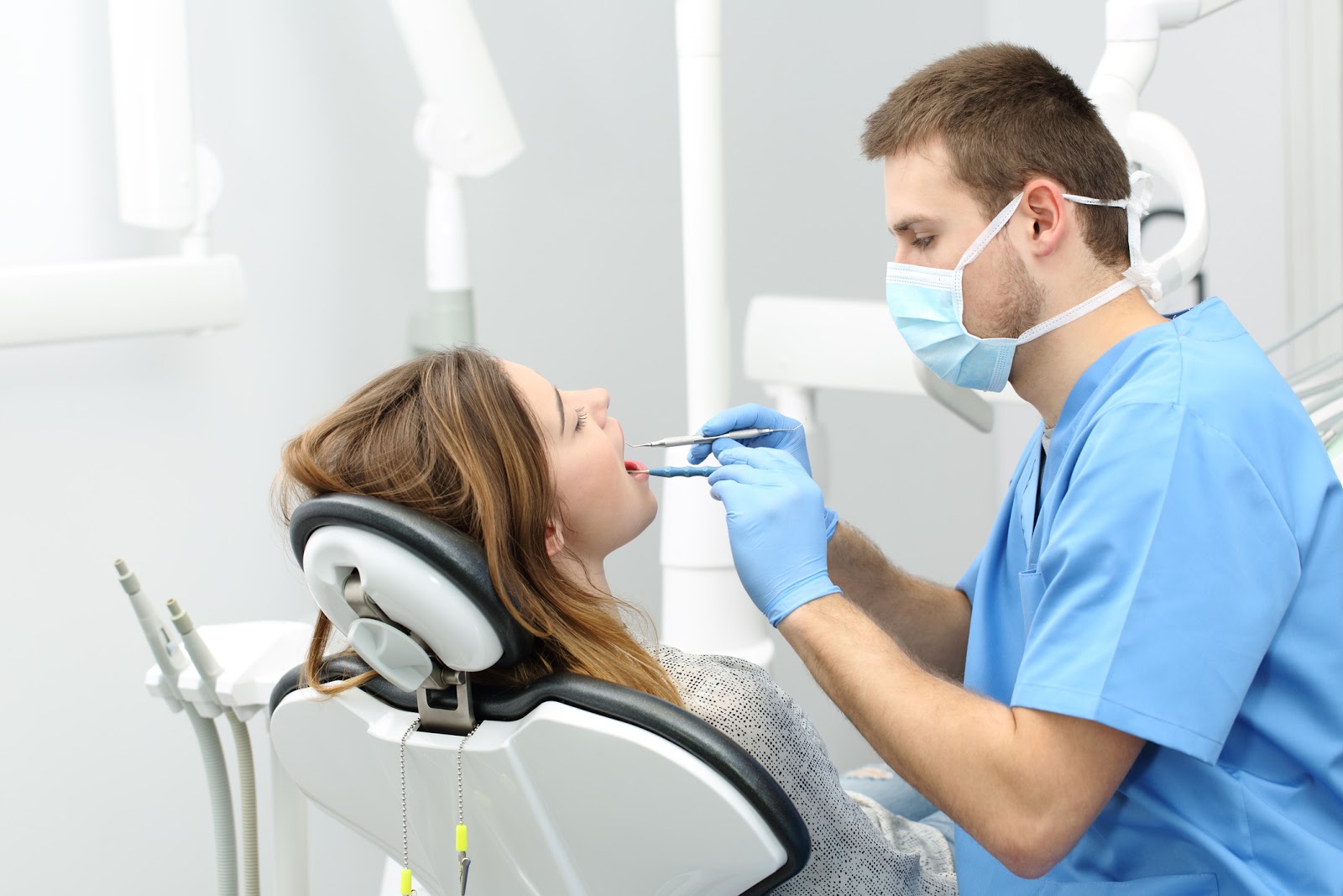 Happy dentist working making a dental hygiene to a patient